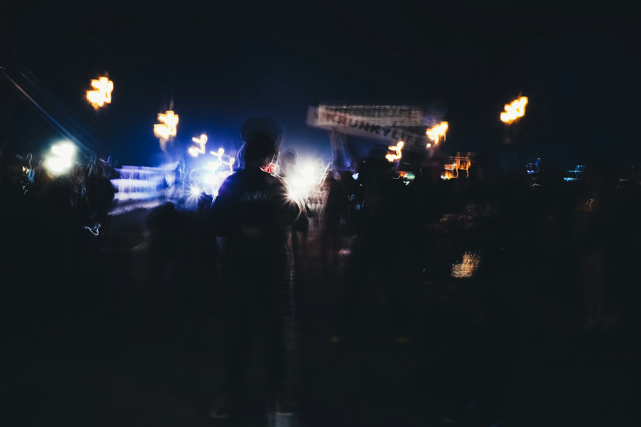 A concert crowd beneath blue and golden stage lights